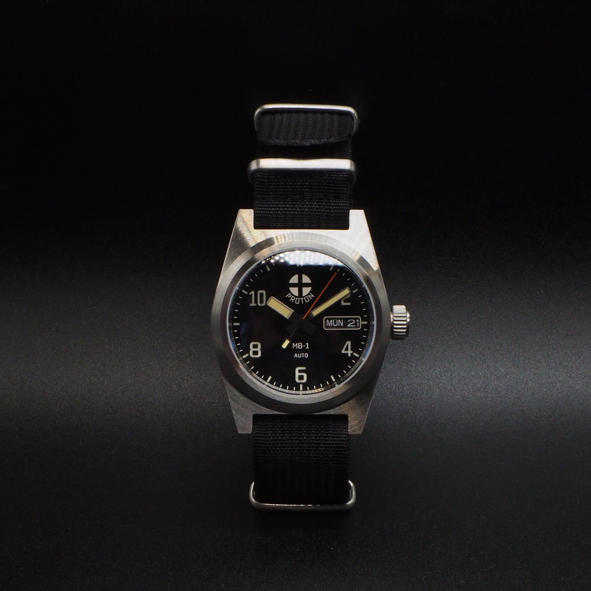 Wristwatch with black strap and metallic case on a dark background