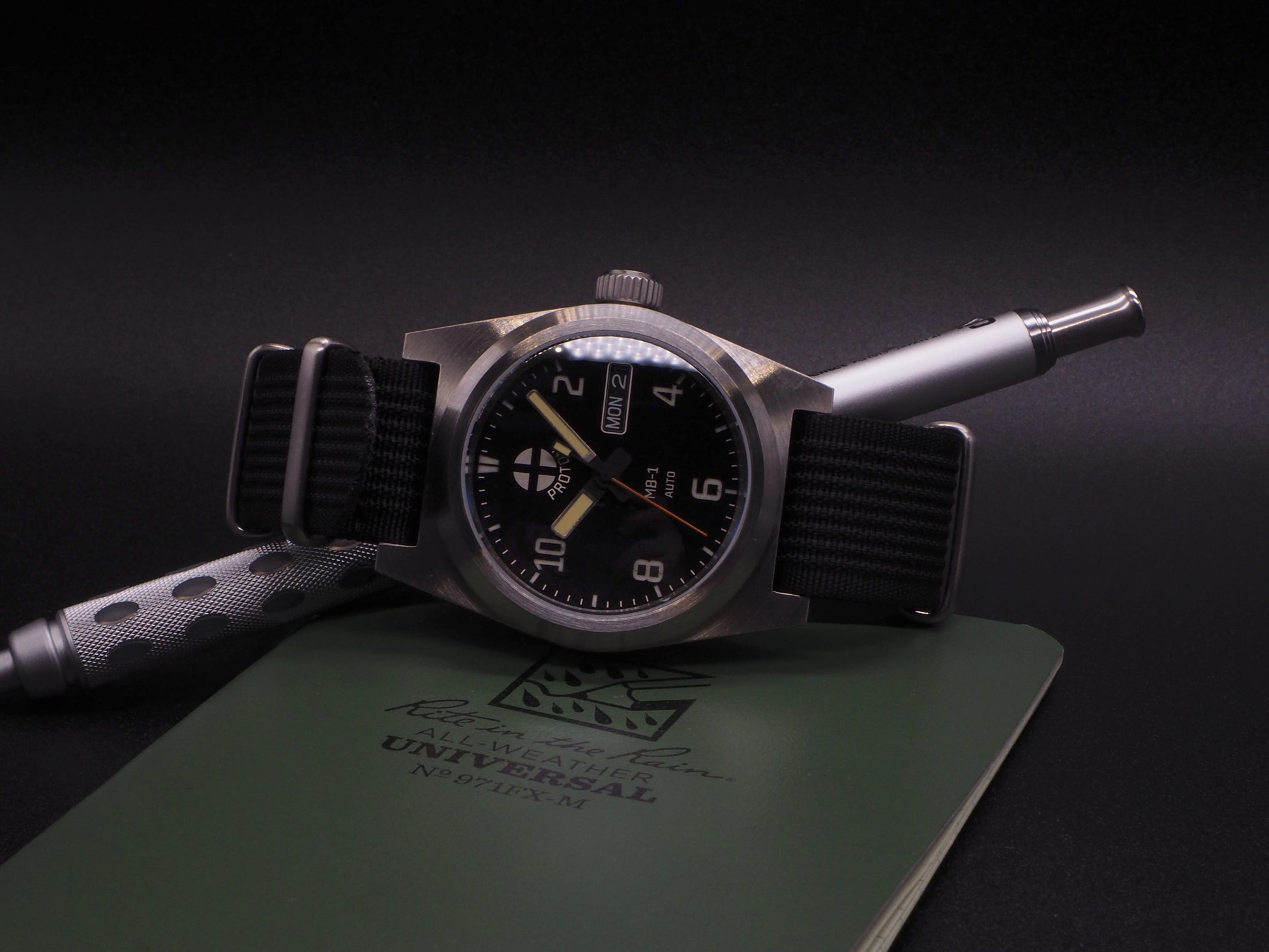 Watch with a black strap on a green notebook against a dark background