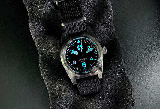 Mechanical men's field watch with lumed dial and hands on black nylon strap