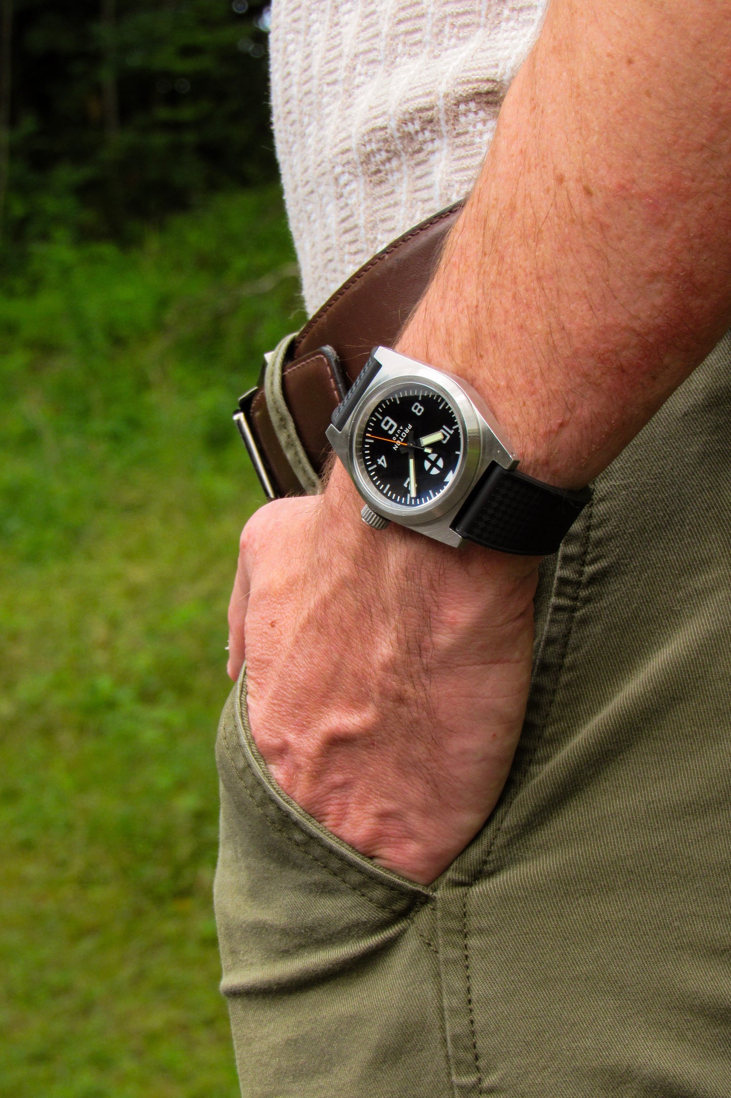 Automatic field watch with mechanical movement on wrist and trees in background